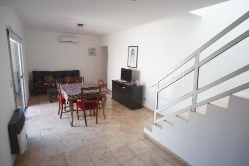 sala de estar con mesa y sillas y escalera en Moderno departamento caseros, en Caseros