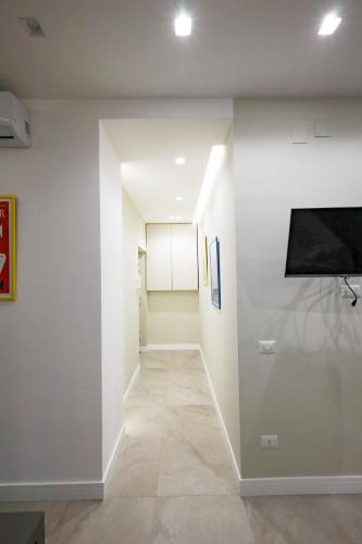a hallway with a flat screen tv and a wall at Calypso Home in Torre del Greco