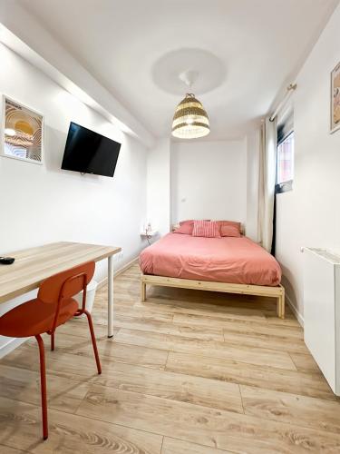 une chambre avec un lit et un bureau dans l'établissement NOA - Appartement familial très proche Paris et Vincennes - Parking free, à Joinville-le-Pont