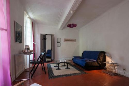 a living room with a blue couch and a table at L'Enclos in Lorgues