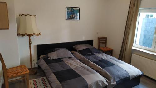 ein Schlafzimmer mit einem Bett und einer Lampe und einem Fenster in der Unterkunft Haus im Garten in der Nähe von Köln-Messe in Bergisch Gladbach