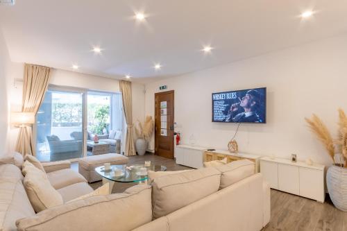 a living room with a couch and a table at Modern Beautiful Pool And Sea Apt Qawra - Happy Rentals in Qawra