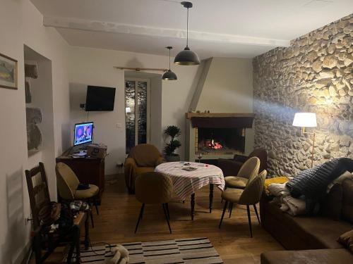 ein Wohnzimmer mit Tisch und Kamin in der Unterkunft Nichoir des gorges in Montolieu