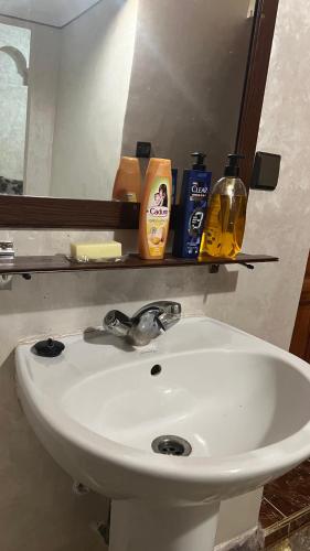 a white sink in a bathroom with a mirror at Dar Calme Chez El Bouhali in Skoura