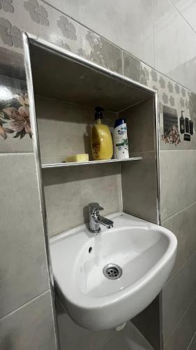 a white sink in a bathroom with a shelf at Dar Calme Chez El Bouhali in Skoura