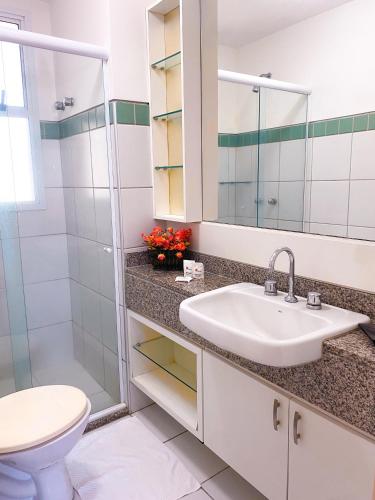 a bathroom with a sink and a toilet and a mirror at Planet Pé na Areia PDD in Aquiraz