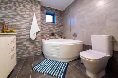 a bathroom with a tub and a toilet and a sink at Asmani in Kato Asites