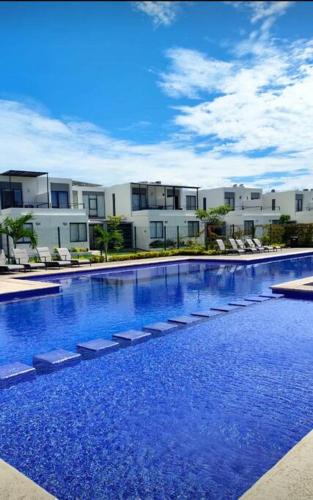 a large swimming pool with chairs and buildings in the background at Casa Nueva con Alberca Puerto Vallarta in Puerto Vallarta