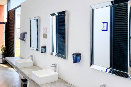 two sinks in a white bathroom with mirrors at Casa Nueva con Alberca Puerto Vallarta in Puerto Vallarta