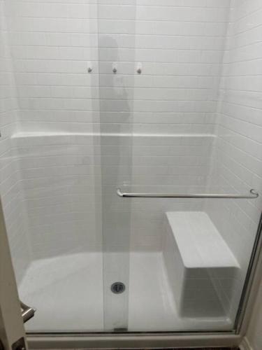 a shower with a glass door next to a toilet at A Tranquil Haven with Elegance in Menifee