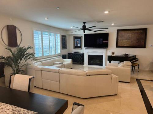 a living room with white furniture and a piano at A Tranquil Haven with Elegance in Menifee