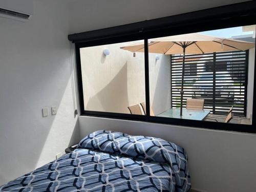 a bedroom with a large window and a table with an umbrella at Casa Nueva con Alberca Puerto Vallarta in Puerto Vallarta