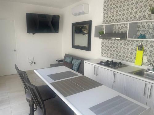 a kitchen with a sink and a table with chairs at Casa Nueva con Alberca Puerto Vallarta in Puerto Vallarta