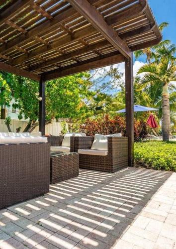 a patio with a wooden pergola and chairs at Beach Living at Island Pine Villas (BLJ) in George Town