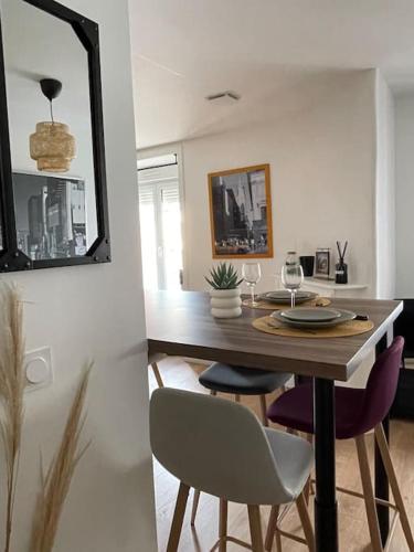 a dining room with a table with chairs and a mirror at Duplex le Brooklyn en Plein centre de Mordelles in Mordelles