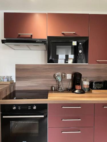 a kitchen with a stove and a microwave at Duplex le Brooklyn en Plein centre de Mordelles in Mordelles