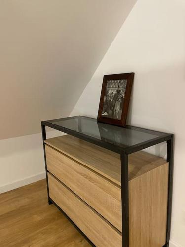 a glass cabinet with a picture on top of it at Duplex le Brooklyn en Plein centre de Mordelles in Mordelles