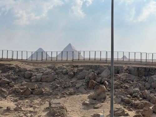 a view of a beach with rocks and a pole at Pyramids Panorama Suites in ‘Ezbet `Abd el-Ḥamîd