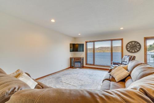 a living room with a couch and a clock on the wall at Dock and Views Waterfront Home in Wabasha! in Wabasha