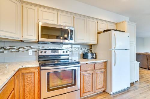 a kitchen with white appliances and wooden cabinets at Dock and Views Waterfront Home in Wabasha! in Wabasha