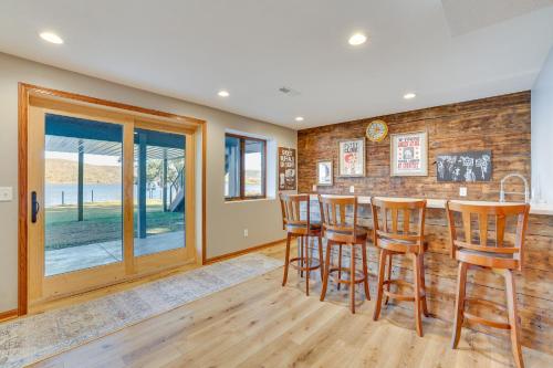 a kitchen with a bar with wooden stools at Dock and Views Waterfront Home in Wabasha! in Wabasha