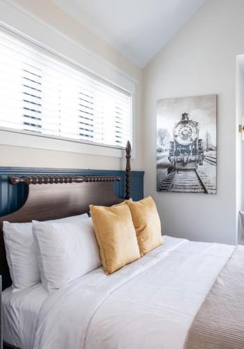 a bedroom with a bed with white sheets and a clock on the wall at The Hen Houses in Wildwood