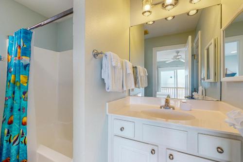 a bathroom with a sink and a mirror and a shower at Captiva by Meyer Vacation Rentals in Gulf Shores