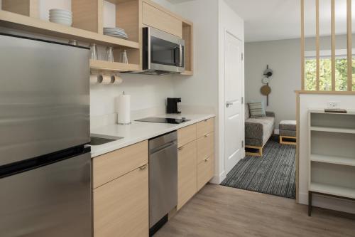 a kitchen with a stainless steel refrigerator and cabinets at TownePlace Suites by Marriott Eugene in Eugene