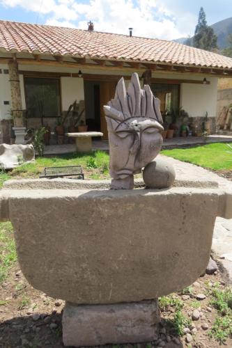 a statue sitting on top of a stone bench at casa de campo-arin in Huaran