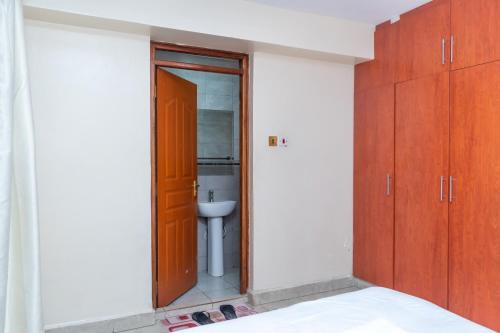 a bathroom with a sink and a toilet in a room at Luxury Two Bedroom Master & Suite Apartment in Nairobi
