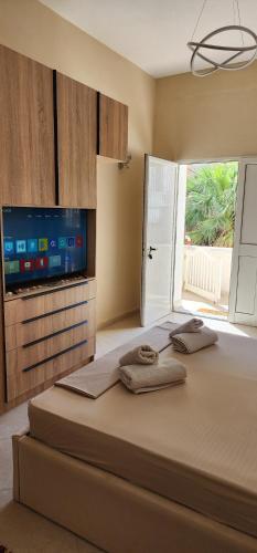 a bedroom with a large bed with a flat screen tv at Armando's house Durres in Durrës