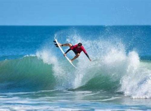 a man riding a wave on a surfboard in the ocean at Oasis 203 - Symmetry & Serenity in Titusville