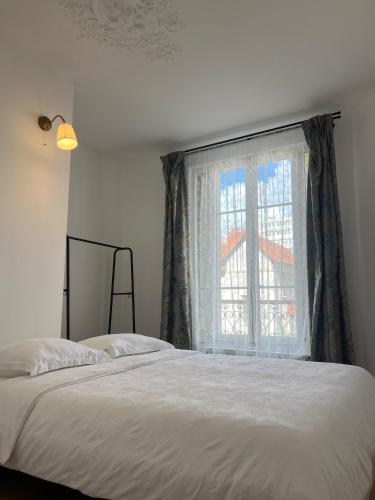 une chambre avec un lit et une fenêtre dans l'établissement Appartement en duplex - M4 et RER B Arcueil-Cachan, à Bagneux