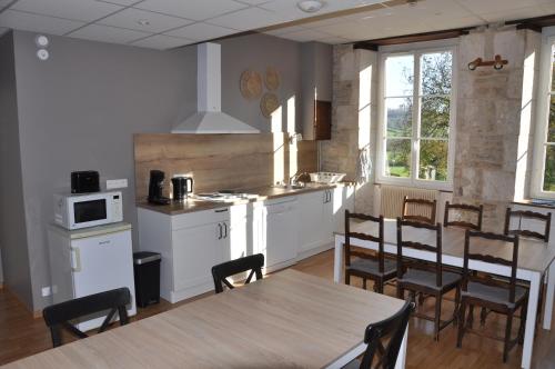 een keuken en eetkamer met een tafel en stoelen bij Domaine Ferme Sainte Anne in Langres