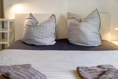 two pillows sitting on top of a bed at Bäckerhus - Ferienwohnung 5 in Wiek auf Rügen 