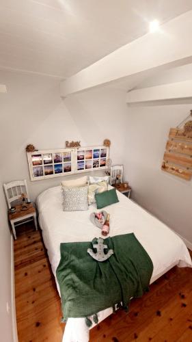 a bedroom with a large white bed with green sheets at Casa Mar do Triângulo in Horta