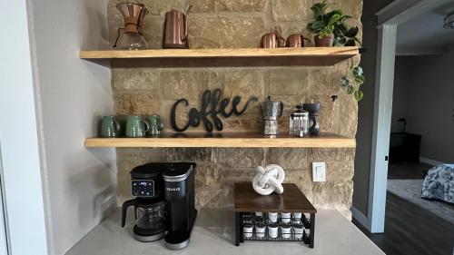 a brick fireplace with a coffee station on a shelf at The Shophouse at Transplant Acres in Bandera