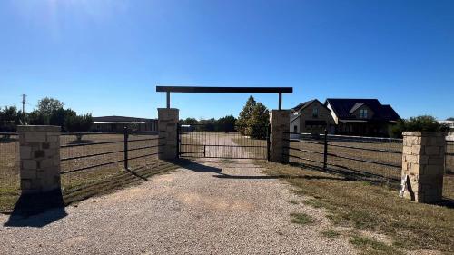 a gate in a field with a fence at The Shophouse at Transplant Acres in Bandera