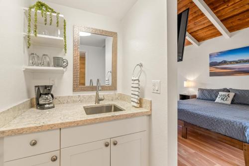 a bathroom with a sink and a bedroom with a bed at Beautiful 2 Br 2.5 Ba Condo Golf Course View, Pool, Hot Tub (209AB) in Princeville