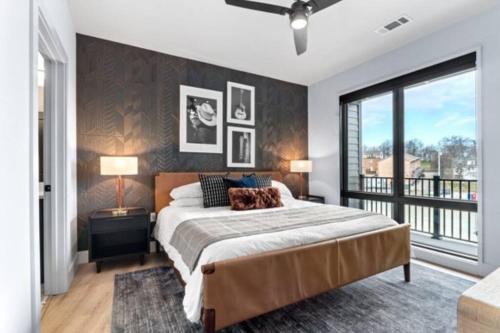 Un dormitorio con una cama grande y una ventana grande. en Electric - Odyssey -Top Floor West End 2 Bedroom - Minutes to Broadway, en Nashville