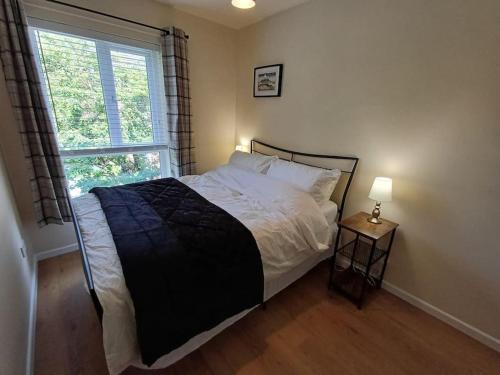 a bedroom with a large bed with a window at Cental Retreat - 2 bedroom apartment in Belfast