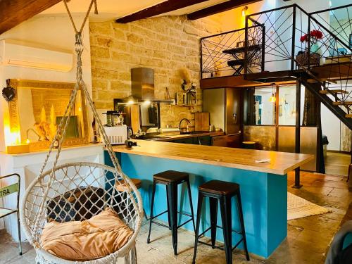 une cuisine avec un îlot bleu avec tabourets dans l'établissement Loft en duplex centre historique, à Montpellier
