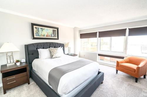 a bedroom with a bed and a chair and windows at Private Apt Close to Train in Stamford