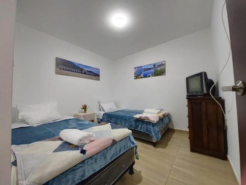 a room with two beds and a tv in it at Apto Vacacional Denis T in Tunja