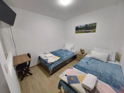 a small room with two beds and a desk at Apto Vacacional Denis T in Tunja