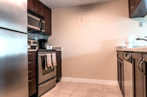 a kitchen with stainless steel appliances and brown cabinets at Private Apt Downtown in Stamford