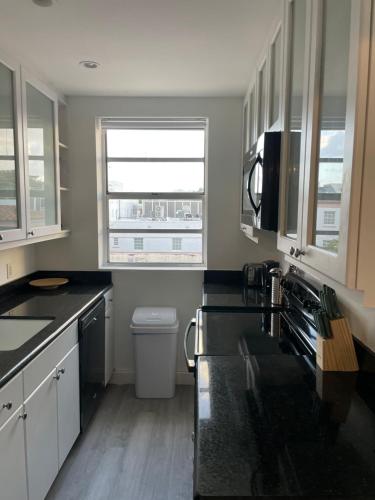 a kitchen with black counter tops and a window at TROPICAL HAVEN POOL & 2BLOCKS TO BEACh in Miami Beach