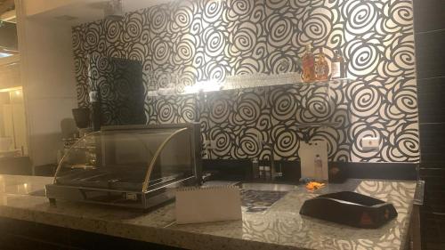 a kitchen counter with a microwave and a wall at CARIBONI in Guarujá