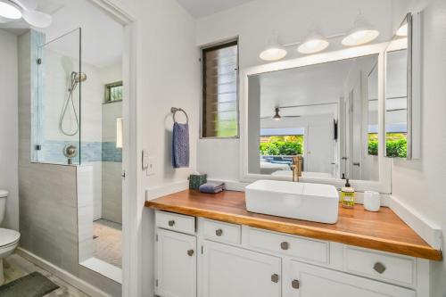 une salle de bain blanche avec un lavabo et une douche dans l'établissement 2 Br Princeville Sands Condo with Pool and Hot Tub (137-A/B), à Princeville