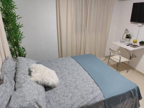 a bedroom with a bed with a blue comforter and a table at Your Tropical HouseRD in La Francia